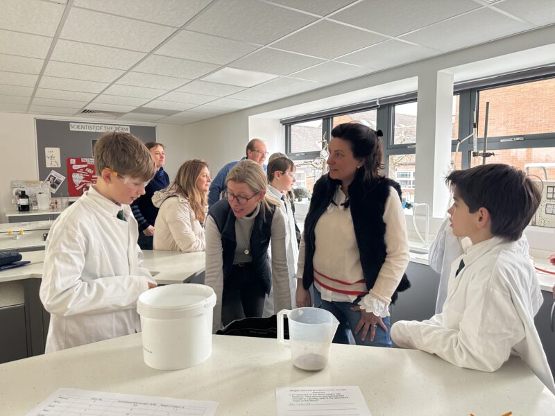 Parents and pupils in school science labs looking at different experiments
