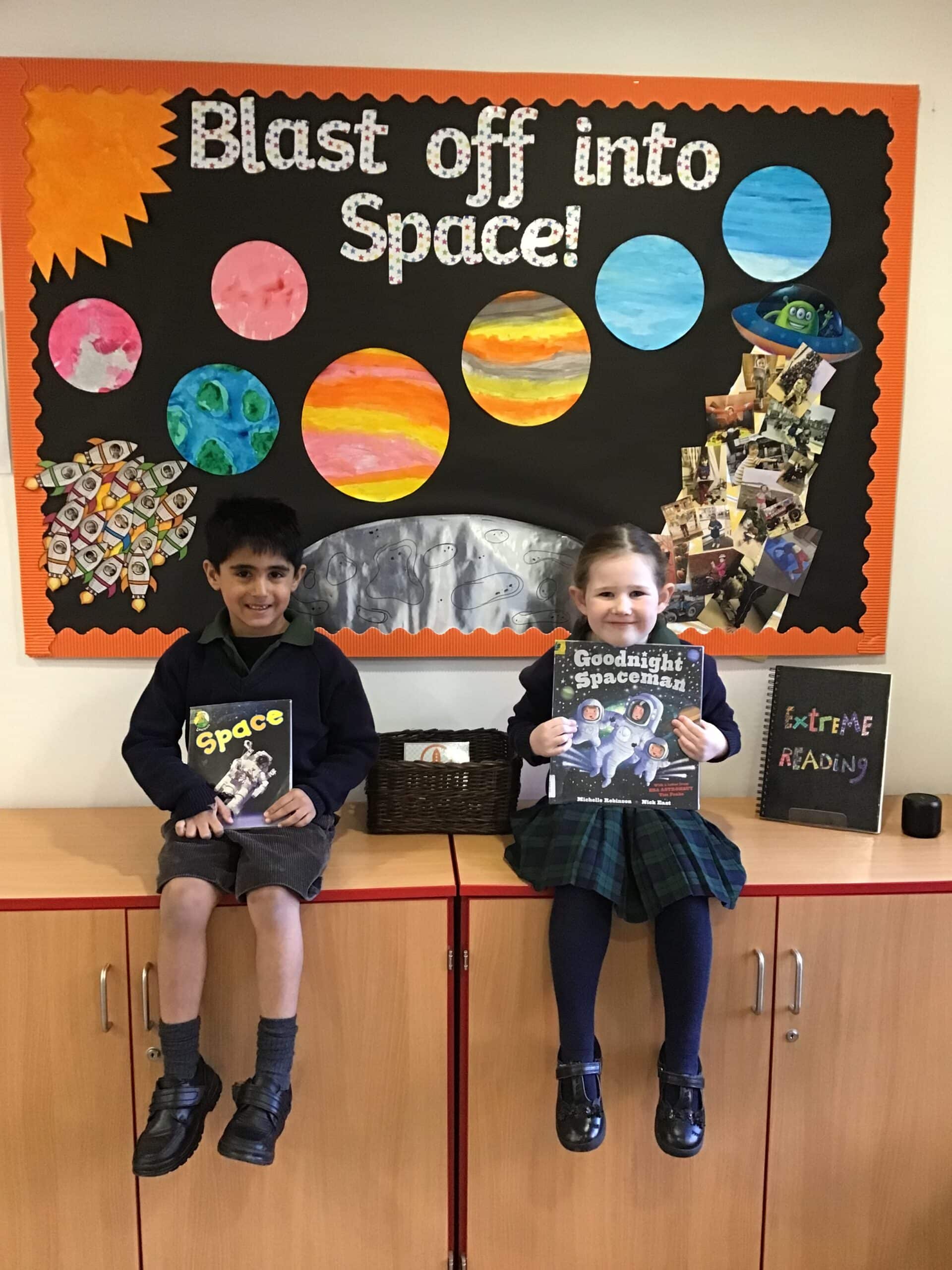 Boy and girl holding books about space